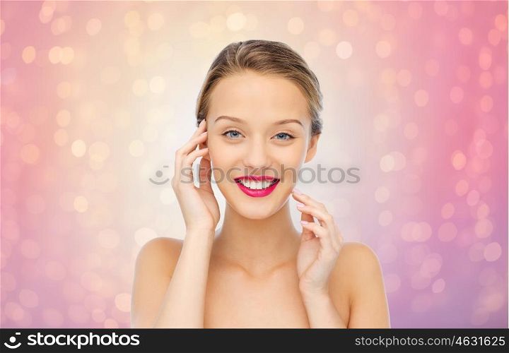 beauty, people and health concept - smiling young woman face with pink lipstick on lips and shoulders over rose quartz and serenity lights background