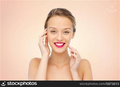 beauty, people and health concept - smiling young woman face with pink lipstick on lips and shoulders over beige background