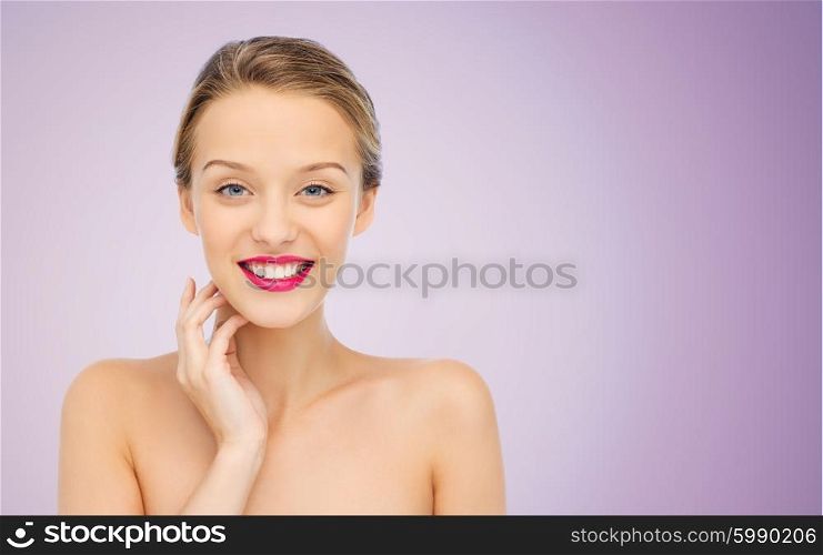 beauty, people and health concept - smiling young woman face with pink lipstick on lips and shoulders over violet background