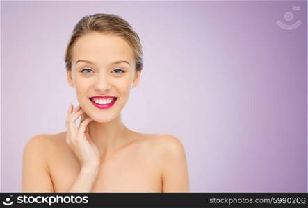beauty, people and health concept - smiling young woman face with pink lipstick on lips and shoulders over violet background