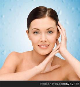 beauty, people and health concept - smiling young woman with bare shoulders over blue wet background