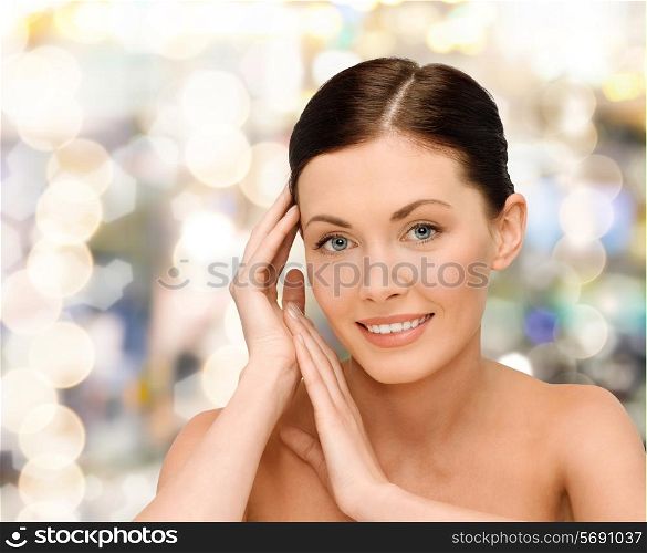 beauty, people and health concept - smiling young woman with bare shoulders over lights background