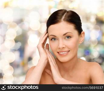 beauty, people and health concept - smiling young woman with bare shoulders over lights background
