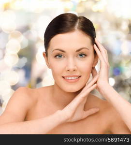 beauty, people and health concept - smiling young woman with bare shoulders over lights background