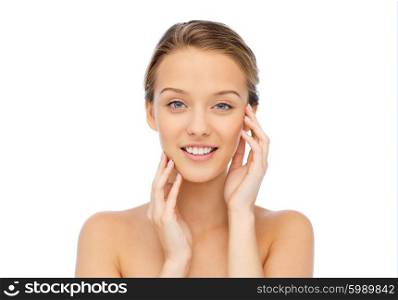 beauty, people and health concept - smiling young woman with bare shoulders touching her face