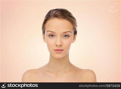beauty, people and health concept - young woman face and shoulders over beige background