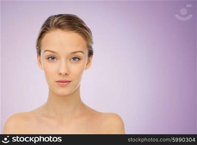 beauty, people and health concept - young woman face and shoulders over violet background