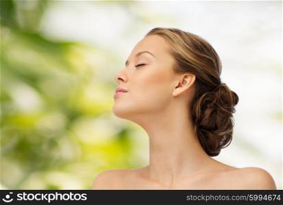 beauty, people and health concept - young woman face with closed eyes and shoulders side view over green natural background