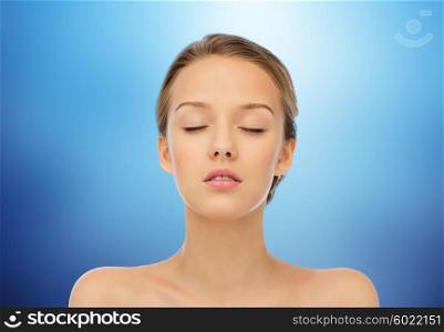 beauty, people and health concept - young woman face with closed eyes and shoulders over marine blue background