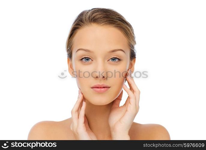beauty, people and health concept - young woman with bare shoulders touching her face