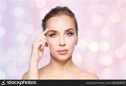 beauty, people and plastic surgery concept - beautiful young woman showing her forehead over rose quartz and serenity lights background