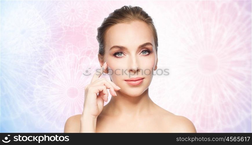 beauty, people and plastic surgery concept - beautiful young woman showing her cheekbone over rose quartz and serenity pattern background