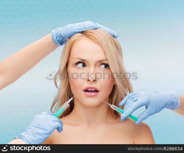 beauty, people and plastic surgery concept - woman face and beautician hands with syringes