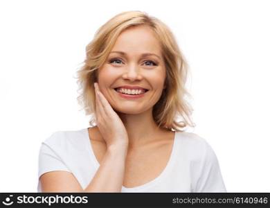 beauty, people and skincare concept - smiling woman in white shirt touching face