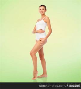 beauty, people, anticellulite and bodycare concept - beautiful young woman in white underwear over green background. beautiful young woman in white underwear