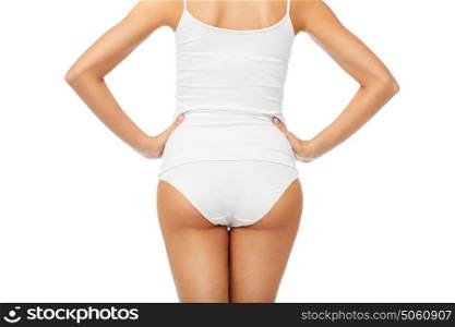 beauty, people, anticellulite and bodycare concept - close up of beautiful young woman body in white underwear from back. close up of woman body in white underwear