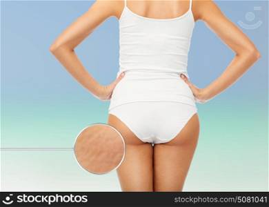 beauty, people, anticellulite and bodycare concept - close up of beautiful young woman body in white underwear from back over beach background. close up of woman body in white underwear