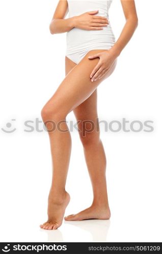 beauty, people, anticellulite and bodycare concept - legs of beautiful young woman in white underwear. legs of beautiful young woman in white underwear
