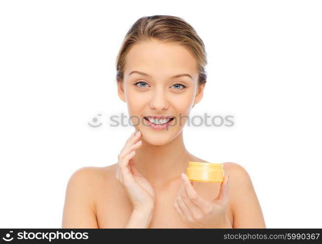 beauty, people, cosmetics, skincare and cosmetics concept - happy young woman applying cream to her face