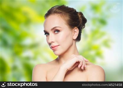 beauty, people, eco and health concept - beautiful young woman face over green natural background
