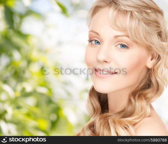 beauty, people, hair care and health concept - beautiful young woman face with long wavy hair over green background