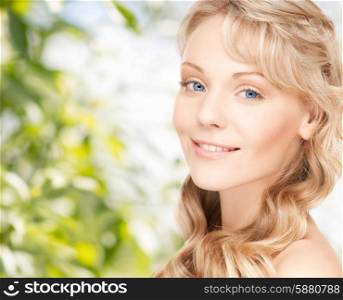 beauty, people, hair care and health concept - beautiful young woman face with long wavy hair over green background