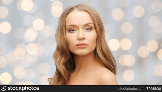 beauty, people, hair care, holidays and health concept - beautiful young woman face over lights background