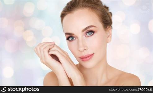 beauty, people, holidays and skin care concept - beautiful young woman face and hands over white background