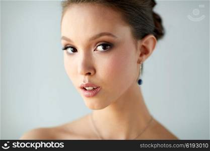 beauty, people, make up and luxury concept - close up of beautiful asian woman or bride with earring