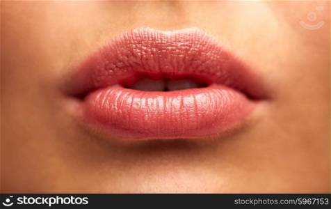 beauty, people, make-up, plastic surgery and cosmetics concept - close up of young woman lips