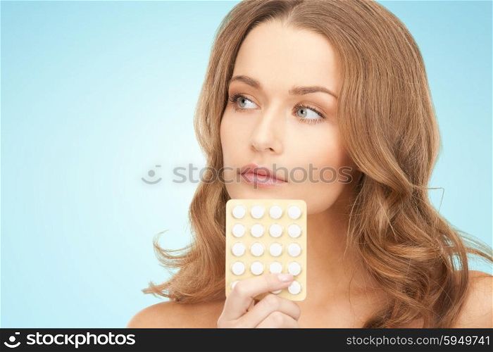 beauty, people, medicine and health care concept - beautiful young woman with medication over blue background