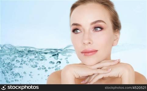 beauty, people, moisturizing and skincare concept - beautiful young woman face and hands over white background