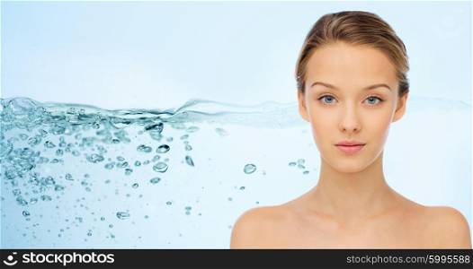 beauty, people, moisturizing, body care and health concept - smiling young woman face with bare shoulders over water splash background