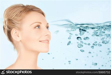 beauty, people, moisturizing, body care and health concept - smiling young woman face over water splash background