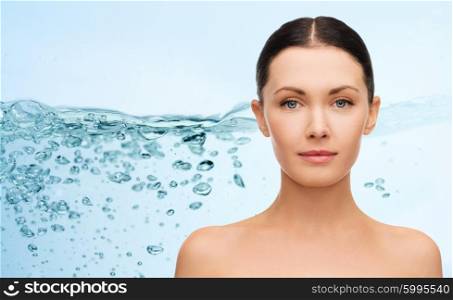 beauty, people, moisturizing, body care and health concept - young woman face with bare shoulders over water splash background