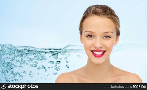 beauty, people, moisturizing, skin care and health concept - smiling young woman face with pink lipstick on lips and shoulders over water splash background