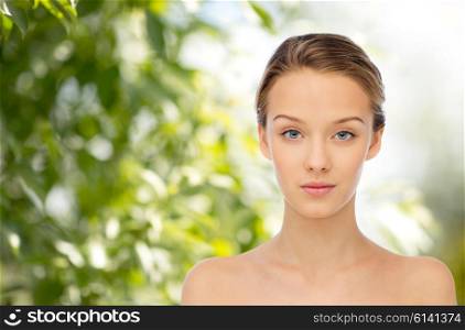 beauty, people, organic, eco and health concept - young woman face and shoulders over green natural background