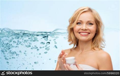 beauty, people, skincare and cosmetics concept - happy middle aged woman with cream jar over water splash with air bubbles background