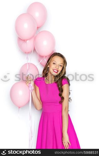 beauty, people, style, holidays and fashion concept - happy young woman or teen girl in pink dress with helium air balloons