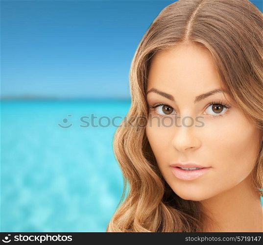 beauty, people, vacation and health concept - beautiful young woman face over blue sea and sky background