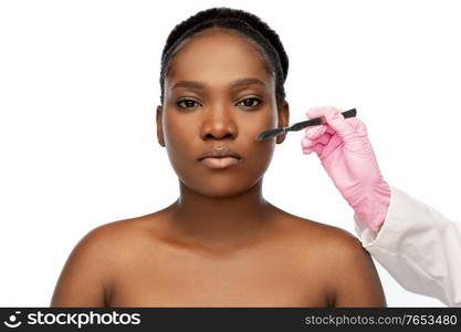 beauty, plastic surgery and people concept - portrait of beautiful young african american woman and hand with scalpel knife over white background. face of african american woman and scalpel knife