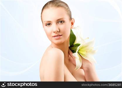 beauty portait of pretty young girl with lilies, she looks in to the lens and smiles and talker lilies on the left shoulder