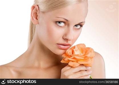 beauty portrait af sweet and nice blond girl with an orange rose on her shoulder