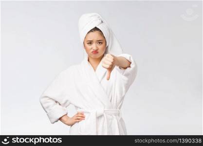 Beauty portrait asian woman looking on camera showing thumb down isolated over white background copy space. Beauty portrait asian woman looking on camera showing thumb down isolated over white background copy space.