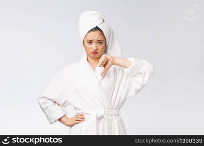 Beauty portrait asian woman looking on camera showing thumb down isolated over white background copy space. Beauty portrait asian woman looking on camera showing thumb down isolated over white background copy space.