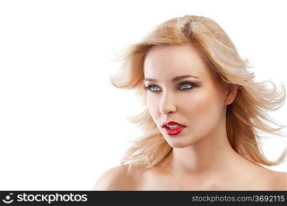 beauty portrait close up of very cute blond girl with hair style flying in wind, she is turned in three quarters and looks at right with actractive eyes
