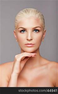 Beauty portrait face of beautiful blond woman with blue eyes and smooth skin, aesthetics skincare concept.