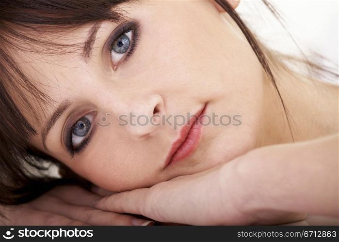 beauty portrait of a girl lying on the floor with her face on her hands