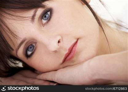beauty portrait of a girl lying on the floor with her face on her hands