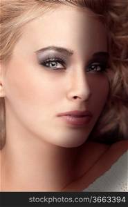 beauty portrait of a gorgeous blonde with grey eyes and a dark metallic grey eye make up